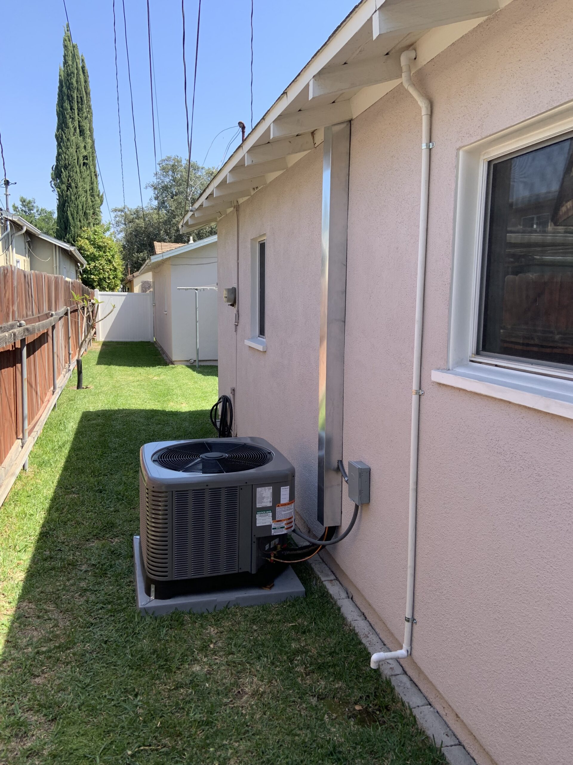 HVAC technician inspecting an outdoor air conditioning unit making a buzzing noise at a residential home.